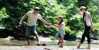 川辺で遊ぶ家族のイメージ写真