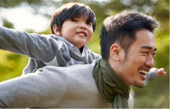 子供をおんぶする父親のイメージ写真